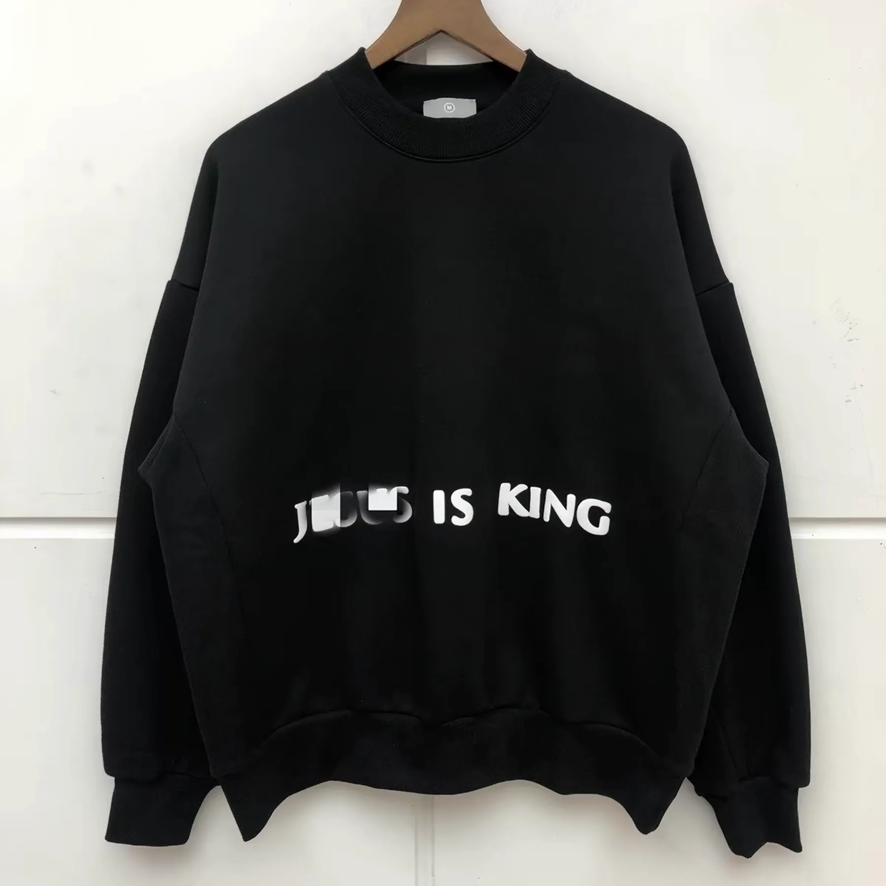 Black graphic crew sweatshirt on a hanger
