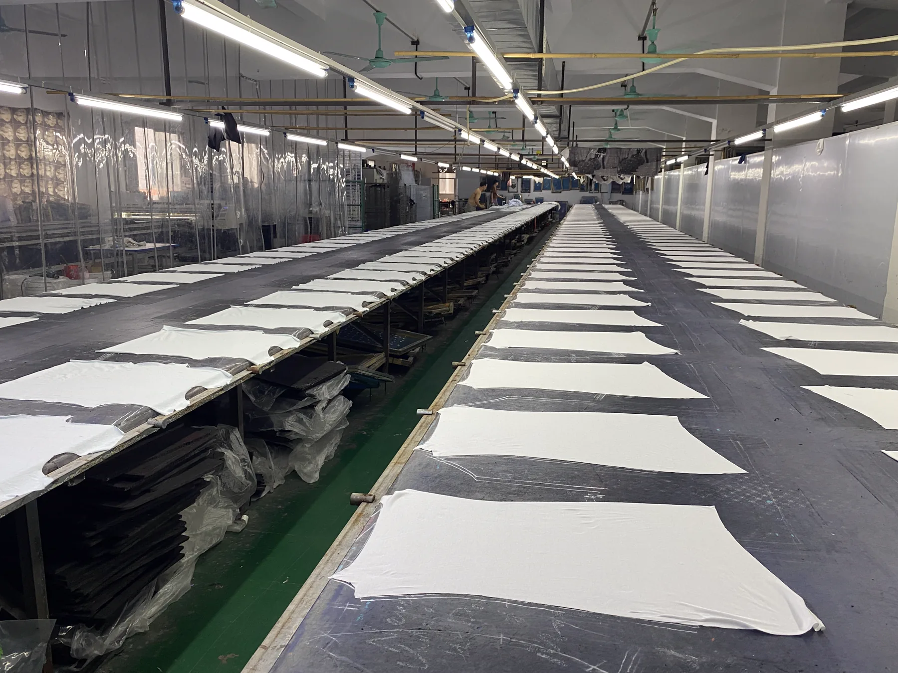 Parallel long printing tables prepared with garment panels