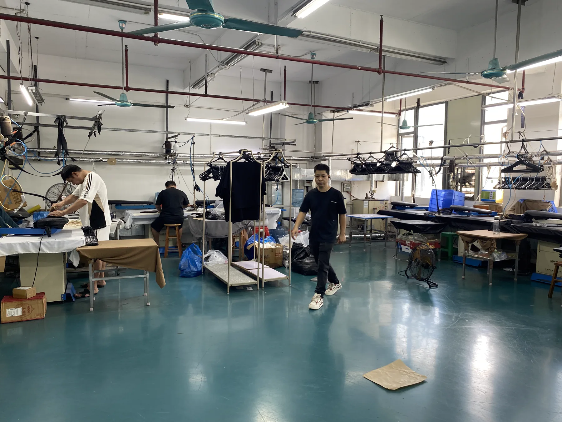 Garment finishing floor with pressing stations and operators